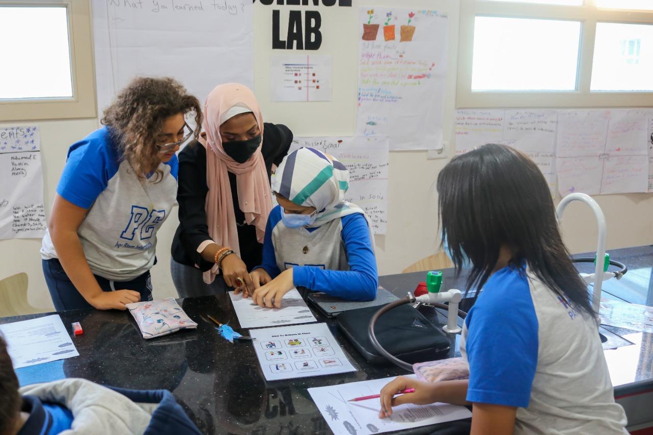A group of people engaged in educational collaboration and hands-on activities in a classroom or laboratory setup at IVY STEM International School.