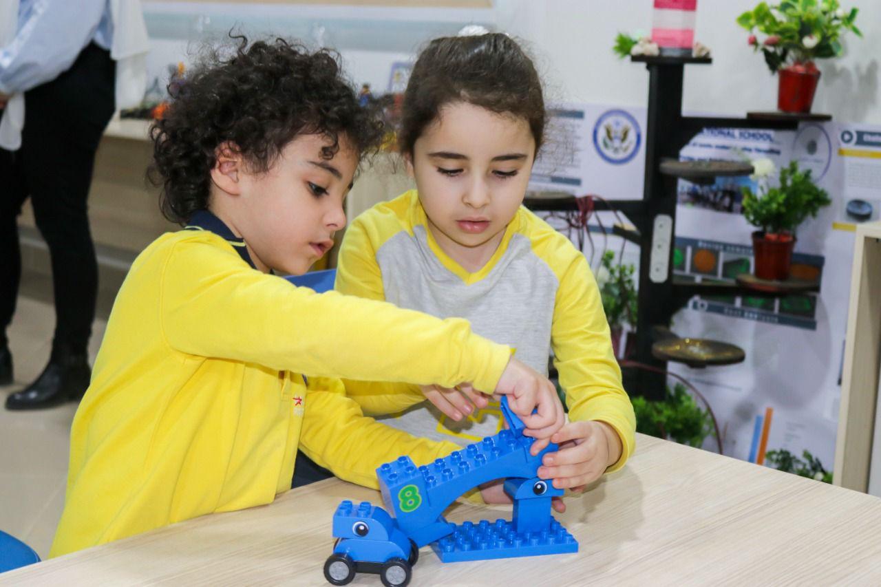 Two children at IVY STEM International School engaged in playing with a building block toy set, developing motor skills and problem-solving abilities.