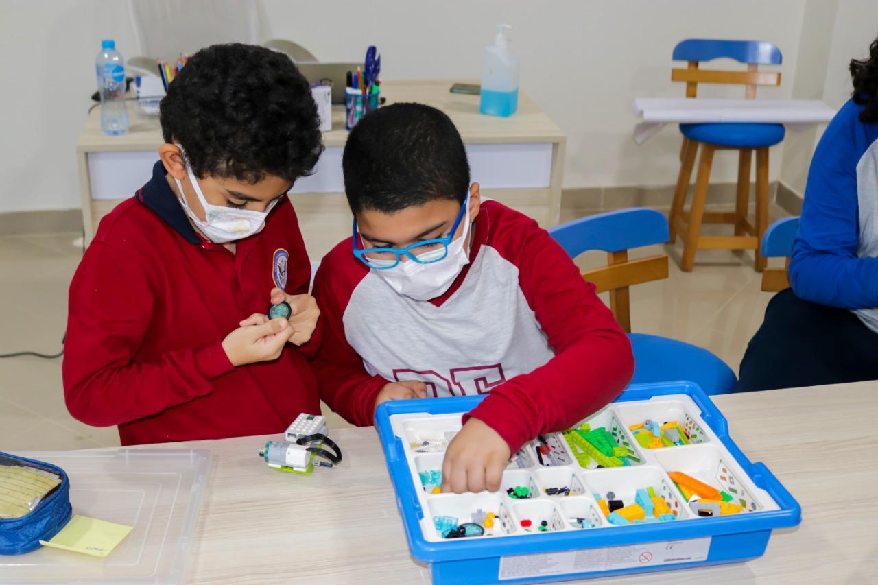 Students at IVY STEM International School engaged in a robotics activity. They are seen working with a robotics or electronics kit, exploring components and building a robotic device. The school's emphasis on STEM education encourages hands-on learning experiences like this.
