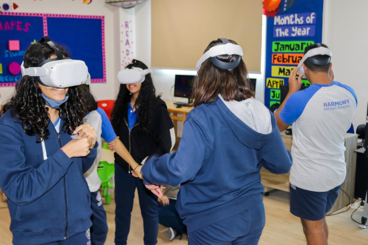 Students at IVY STEM International School participating in an interactive educational activity using virtual reality headsets in a classroom setting. The students are engaged in a game or educational experience, with educational decorations and resources visible in the background.