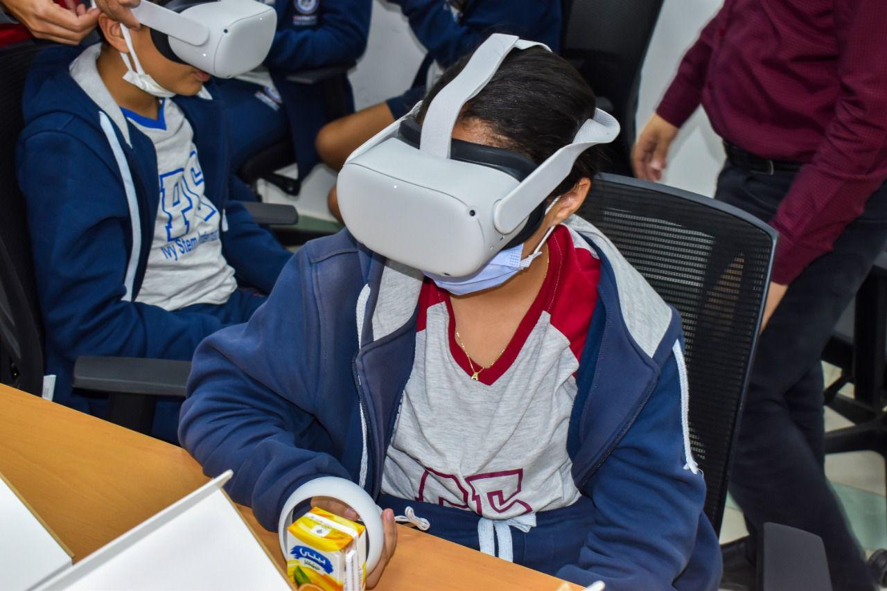 The image depicts students at IVY STEM International School using virtual reality (VR) headsets in a classroom setting. They are actively engaged with VR content, enhancing their learning experience through interactive technology.